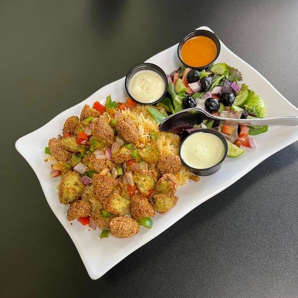 ichop's Mediterranean falafel platter with rice, salad, and three dipping sauces on a white plate.