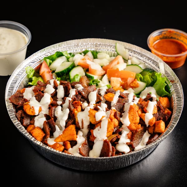 ichop's Mediterranean platter with chicken, beef, salad, and white sauce in a foil container.