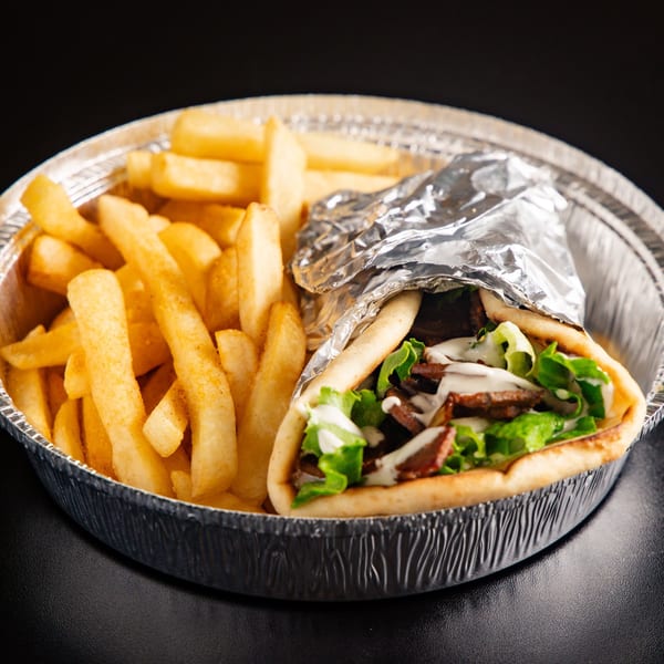ichop Mediterranean gyro with meat, lettuce, and sauce, alongside fries in a foil container.