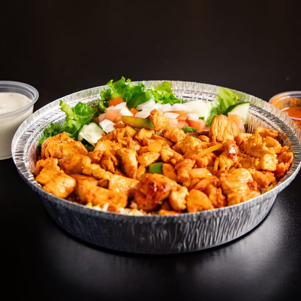 ichop Mediterranean chicken and rice bowl with salad, white sauce, and red sauce.